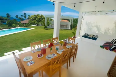a dining table and chairs in a house with a pool at Casa Blava with AC in Las Galeras