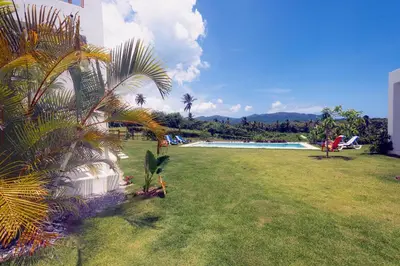 a large yard with a swimming pool and a grass field at Villa Cuatro Peces in Las Galeras