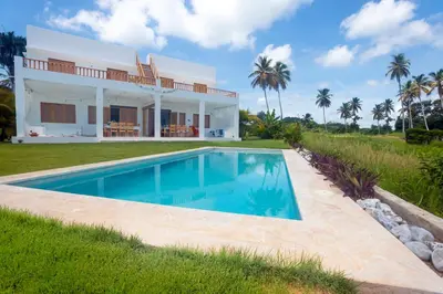 a villa with a swimming pool in front of a house at Villa Cuatro Peces in Las Galeras