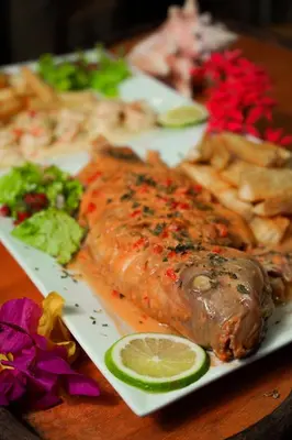 a plate of food with a piece of fish and vegetables at CHALET TROPICAL Hotel & Pool Bar Restaurant in Las Galeras