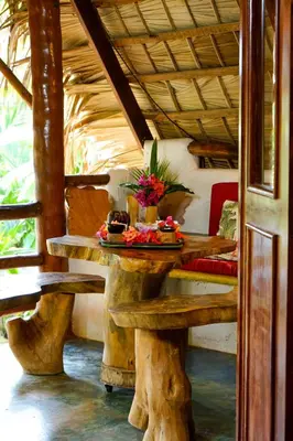 a wooden table with flowers on it in a room at CHALET TROPICAL Hotel & Pool Bar Restaurant in Las Galeras