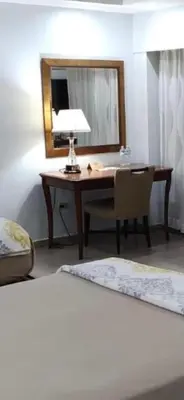 a desk with a lamp and a chair in a room at Micro Hotel Condo Suites in Santo Domingo