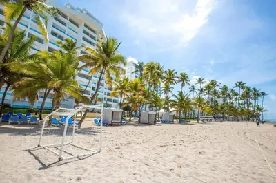 a volley ball hoop on a beach with palm trees at Beach Apartment - Marbella, Juan Dolio!! Getaway Offer!! in Juan Dolio
