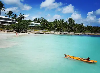 a yellow boat in the water next to a beach at Hotel Villa Serena in Las Galeras