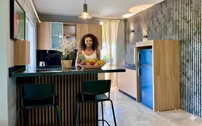 a woman standing at a kitchen counter with a bowl of fruit at Las Galeras Village Ecolodge in Las Galeras