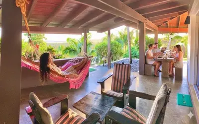 a group of people sitting in a hammock on a porch at Las Galeras Village Ecolodge in Las Galeras