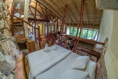 a room with a bed with white sheets in it at Paraiso Caño Hondo in Los Guineos Perdidos