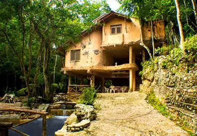 a house sitting on the side of a mountain at Paraiso Caño Hondo in Los Guineos Perdidos