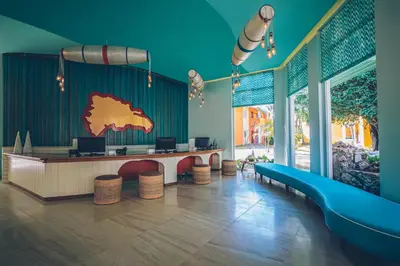a waiting room with a table and chairs in a room at Iberostar Selection Coral Bavaro - All Inclusive in Punta Cana