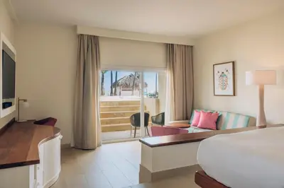 a hotel room with a bed and a living room at Iberostar Selection Coral Bavaro - All Inclusive in Punta Cana