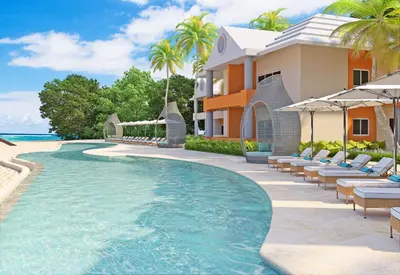 a villa with a swimming pool next to a resort at Iberostar Selection Coral Bavaro - All Inclusive in Punta Cana