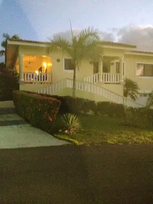 a white house with a white fence and palm trees at Elegant Villa with Sea View in Sosúa | Private Pool in Sosúa