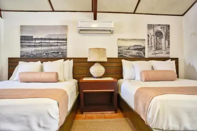a bedroom with two beds and a table with a lamp at El Morro Eco Adventure Hotel in San Fernando de Monte Cristi