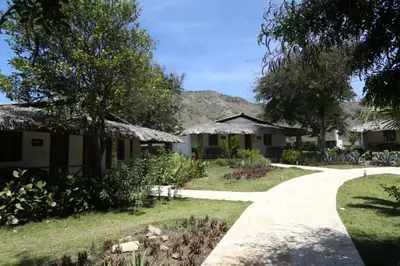 a path to a house with a mountain in the background at El Morro Eco Adventure Hotel in San Fernando de Monte Cristi