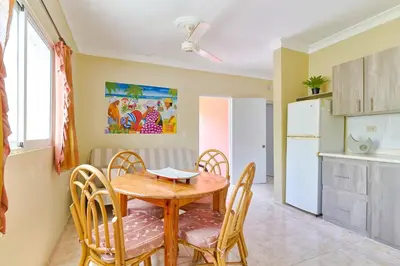 a kitchen and dining room with a table and chairs at Parco del Caribe in Boca Chica