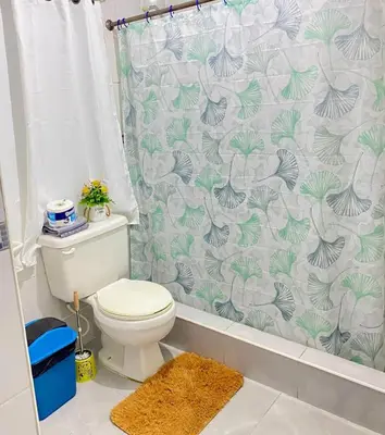 a bathroom with a toilet and a shower curtain at Dre Broeders Apartments Juan Dolio in Juan Dolio