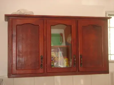 a wooden cabinet in a kitchen with food inside at Dre Broeders Apartments Juan Dolio in Juan Dolio