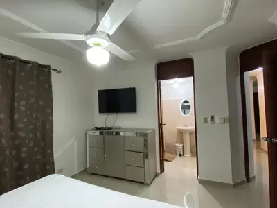 a bedroom with a bed and a tv on the wall at 1Dom Rep - Huge cozy 3 bedrooms - close to all transportation Jacobo Majluta - Residencial Paradise V Colina Arroyo 1 in Santo Domingo