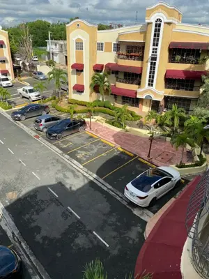 a parking lot with cars parked in front of a building at 1Dom Rep - Huge cozy 3 bedrooms - close to all transportation Jacobo Majluta - Residencial Paradise V Colina Arroyo 1 in Santo Domingo