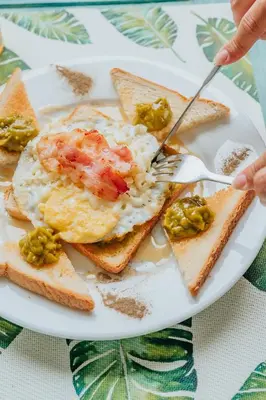 a plate of breakfast food with eggs and toast at Hotel Checkin El Cortecito in Punta Cana