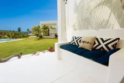 a blue couch on a porch with a view of a yard at Villa Kalfu with AC in Las Galeras