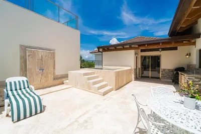 a patio with a table and chairs in front of a house at Suites at Grand Laguna Beach by Calisto Stays in Sosúa