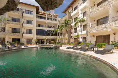 a swimming pool in the middle of a building with chairs and a pool at Suites at Grand Laguna Beach by Calisto Stays in Sosúa