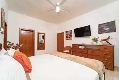a bedroom with a bed and a dresser with a tv at Suites at Grand Laguna Beach by Calisto Stays in Sosúa