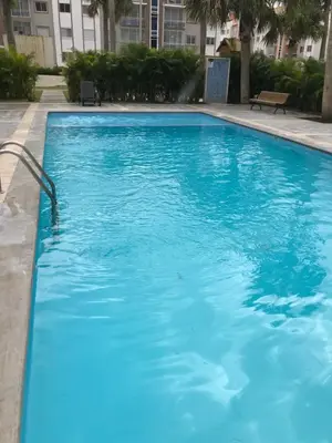 a large blue swimming pool in a building at CONFORTABLE first floor en santiago RD in Santiago de los Caballeros