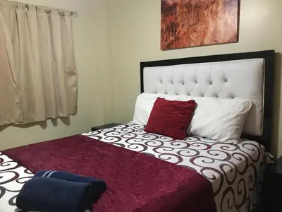 a bedroom with a bed with a red pillow on it at moderno apto frente a la piscina in Santiago de los Caballeros