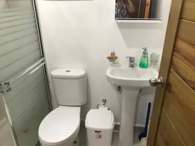 a white bathroom with a toilet and a sink at moderno apto frente a la piscina in Santiago de los Caballeros