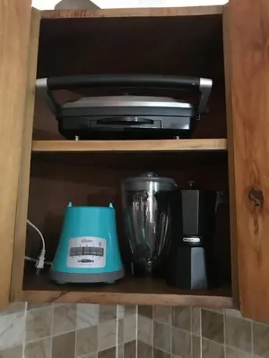 a cabinet with a printer and other appliances in it at moderno apto frente a la piscina in Santiago de los Caballeros
