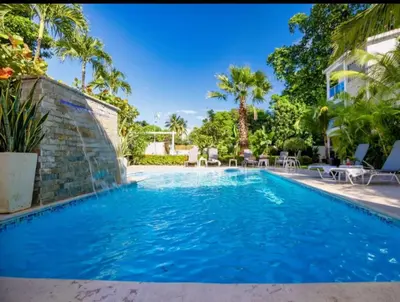 a swimming pool with blue water in a house at Cozy 2br-2bt Apt Near The Beach And Main Street in Sosúa