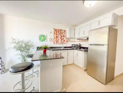 a kitchen with white cabinets and a stainless steel refrigerator at Fully Equipped New 2br Aptdt2mins To The Beach in Sosúa