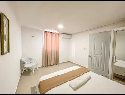 a bedroom with a bed and a chair in it at Fully Equipped New 2br Aptdt2mins To The Beach in Sosúa
