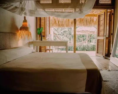 a bedroom with a bed and a table and a window at Bungalow with pool and Air Conditioning near playa Macao in Punta Cana