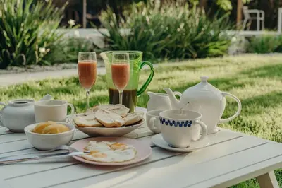 a table with two glasses of champagne and a plate of food at Bungalow with pool and Air Conditioning near playa Macao in Punta Cana