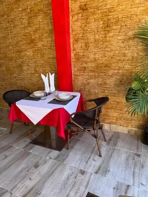 a table with two chairs and a red and white table cloth at Hotel Loro Tuerto in Santa Cruz de Barahona