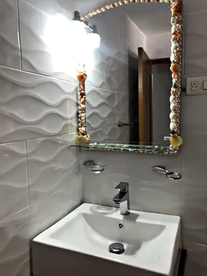 a bathroom with a white sink and a mirror at Fully Equipped New 1br Apt dt 2mins To Beach in Sosúa