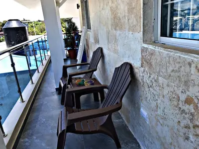 three chairs and a table on a balcony at Fully Equipped New 1br Apt dt 2mins To Beach in Sosúa