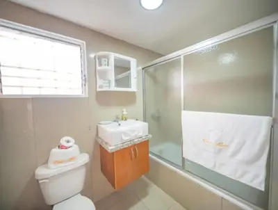 a bathroom with a toilet and a sink and a shower at Fully Equipped New 3br Apt dt 2mins To The Beach in Sosúa