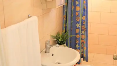 a bathroom with a sink and a shower curtain at Fully Equipped New 3br Apt dt 2mins To The Beach in Sosúa