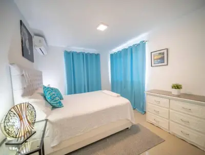 a bedroom with blue curtains and a bed and a dresser at Fully Equipped New 3br Apt dt 2mins To The Beach in Sosúa