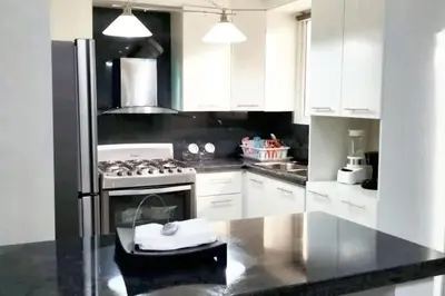 a kitchen with white cabinets and a stove top oven at Spacious house in Santo Domingo Este with garden in Santo Domingo