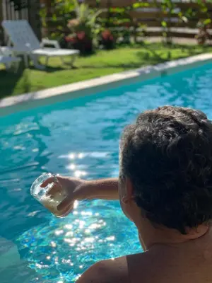 a person holding a bottle in a swimming pool at PUNTA POPY BOUTIQUE HOTEL - Adults Only in Las Terrenas
