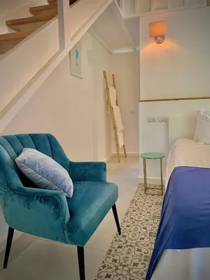 a blue chair and a bed in a room at PUNTA POPY BOUTIQUE HOTEL - Adults Only in Las Terrenas