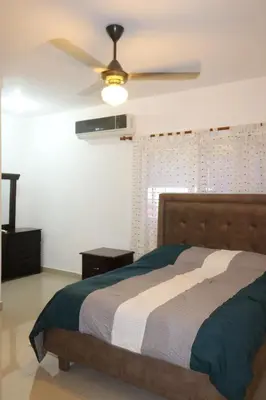 a bedroom with a bed and a ceiling fan at Tu Segundo Hogar en Santiago, La Cuidad CORAZÓN in Santiago de los Caballeros