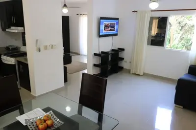 a kitchen and living room with a table and chairs at Tu Segundo Hogar en Santiago, La Cuidad CORAZÓN in Santiago de los Caballeros