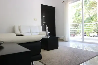 a living room with a white couch and a table at Tu Segundo Hogar en Santiago, La Cuidad CORAZÓN in Santiago de los Caballeros