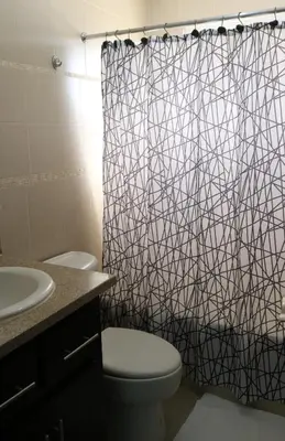 a bathroom with a toilet and a shower curtain at Tu Segundo Hogar en Santiago, La Cuidad CORAZÓN in Santiago de los Caballeros